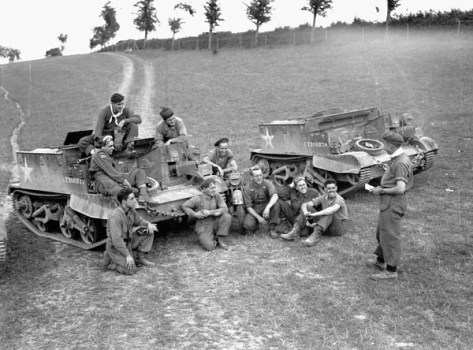 Lieutenant Stan Biggs briefing Universal Carrier flamethrower crews of The Queen’s Own Rifles of Canada, Vaucelles, France, 29 July 1944. (L-R on ground): Corporal H.A. Campbell, Riflemen W.T. Orton, W.K. Cousineau, L.G. Jones, K. White, and Lieutenant Biggs. (L-R on Carrier): Riflemen H.H. Pennell, W. Starostic, C. Tippet, and Sergeant E. Rothwell.